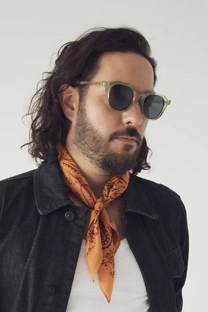 Lunettes de soleil Nika olive portées par un homme avec veste noire et foulard orange - vue de côté