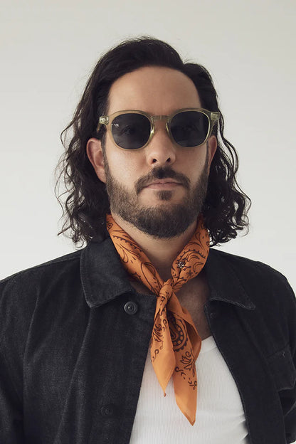 Lunettes de soleil Nika olive portées par un homme avec veste noire et foulard orange - vue de face
