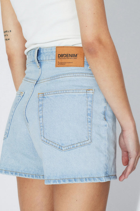 Détail dos du short Nora bleu denim clair avec poches arrière, étiquette et effet vintage.