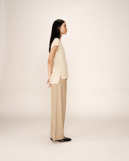 Vue latérale du haut beige en maille lurex sur mannequin