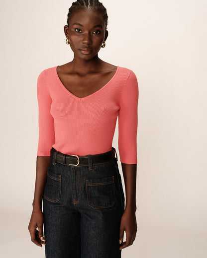 Top en maille côtelée de la marque Grace & Mila, modèle Paige, en coloris rose. Ce haut à manches trois-quarts épouse la silhouette avec élégance et confort. Son col en V met en valeur le décolleté, tandis que sa matière extensible assure un ajustement parfait. Il se porte facilement avec un jean taille haute et une ceinture pour une allure chic et décontractée. Un essentiel féminin et raffiné, idéal pour toutes les saisons.