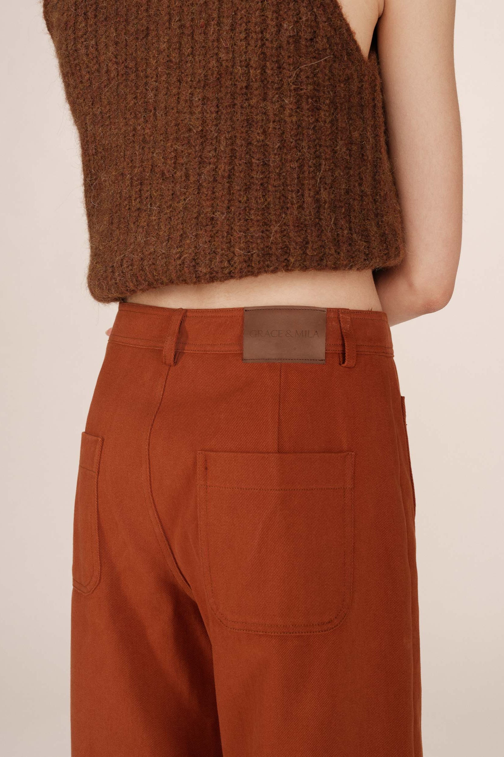 Gros plan du pantalon Sole camel 7/8 porté, poches plaquées arrière et étiquette