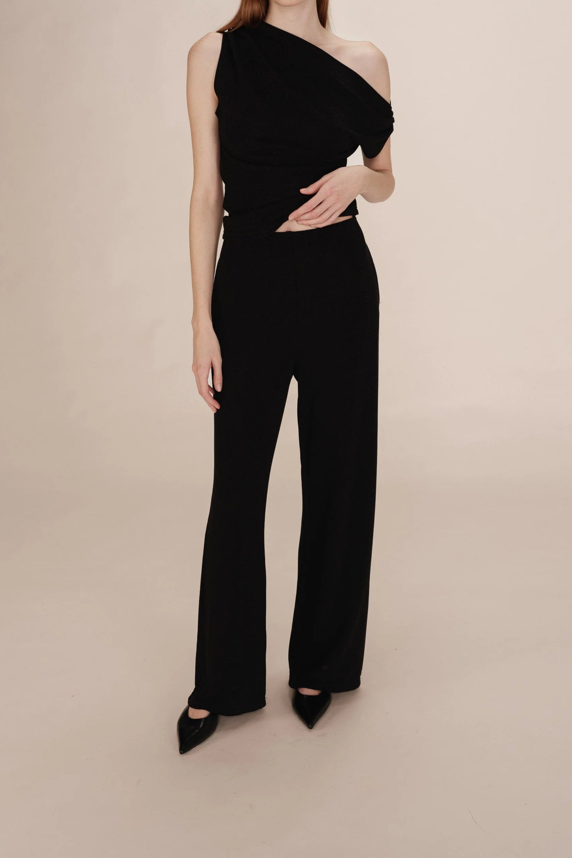 Pantalon Thelma noir porté vue avant coupe large taille haute. Agencé avec le haut Talia.