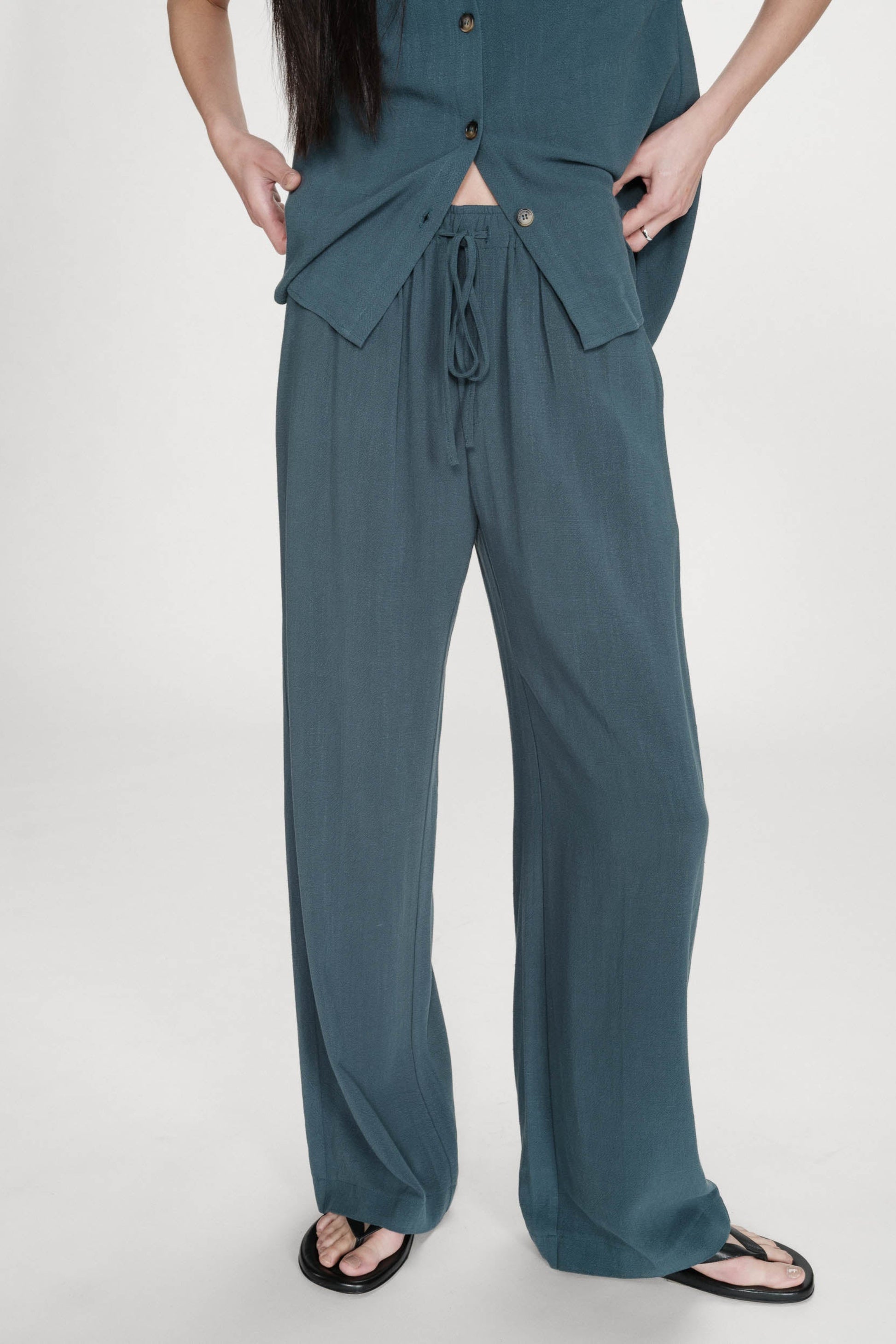 Détail du pantalon émeraude porté avec cordon visible