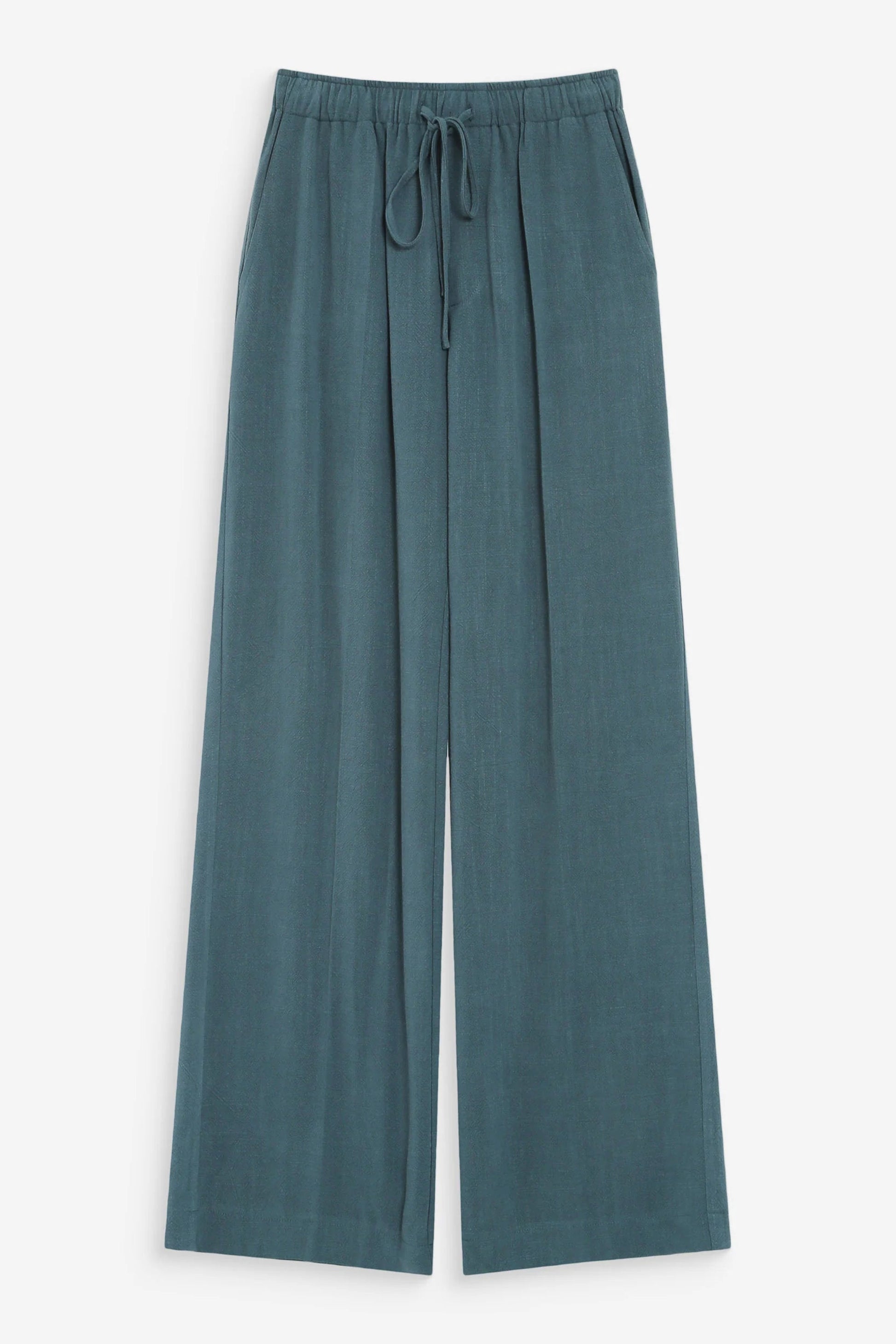 Pantalon large émeraude sur fond neutre avec coupe fluide