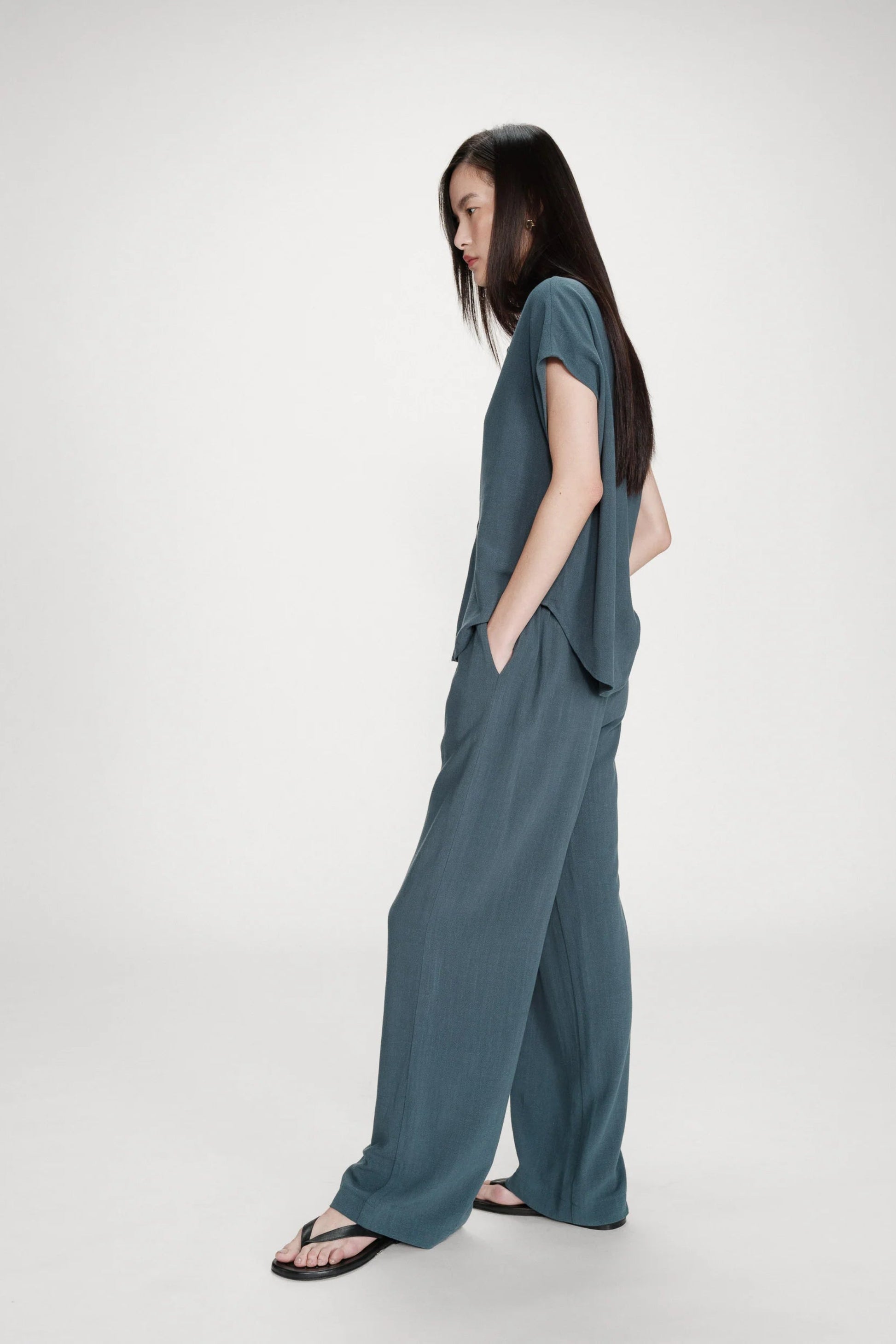 Pantalon émeraude porté de profil avec coupe ample