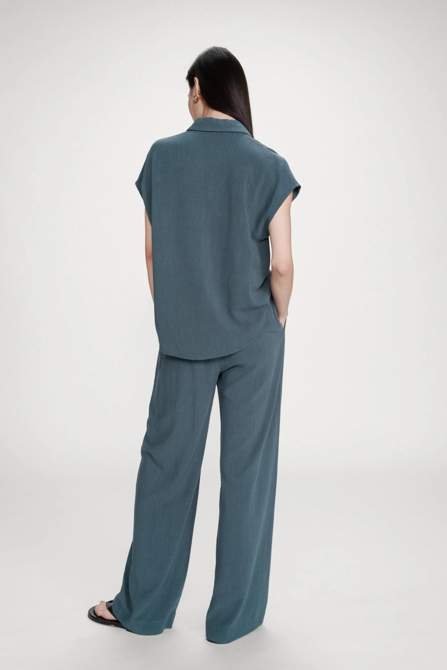 Pantalon émeraude porté avec chemise assortie vu de dos