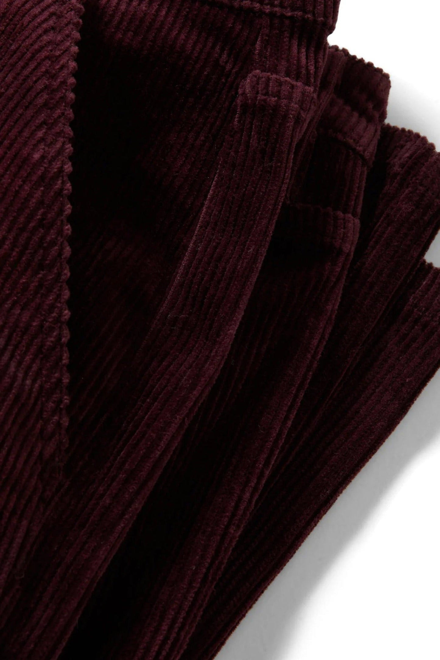 Détail de la jambe en velours côtelé bourgogne, coupe décontractée avec ouverture de jambe large