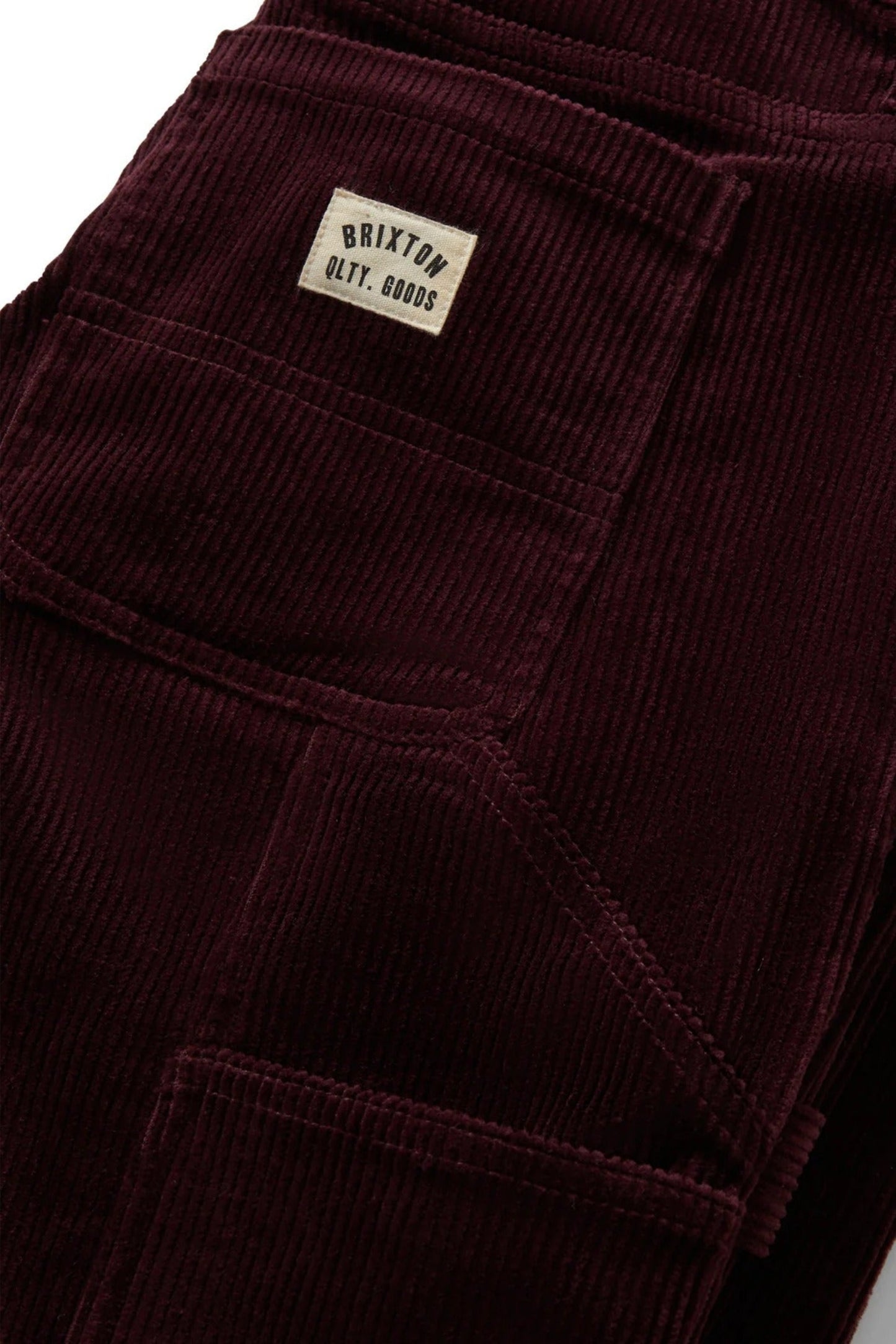 Gros plan sur le velours côtelé bourgogne avec poche utilitaire arrière, tissu texturé en coton légèrement extensible