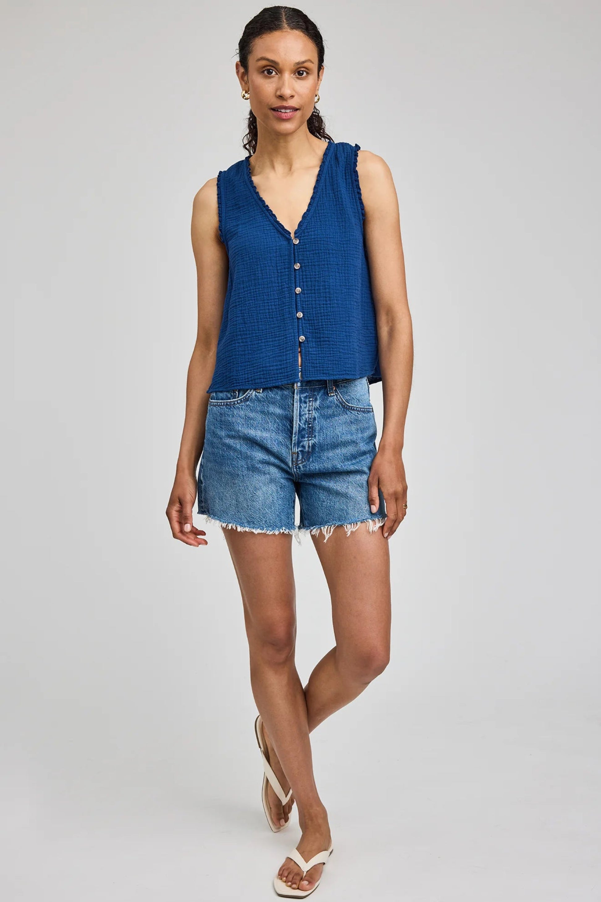Haut sans manches Penelope bleu porté avec un short en jean pour un look estival décontracté.