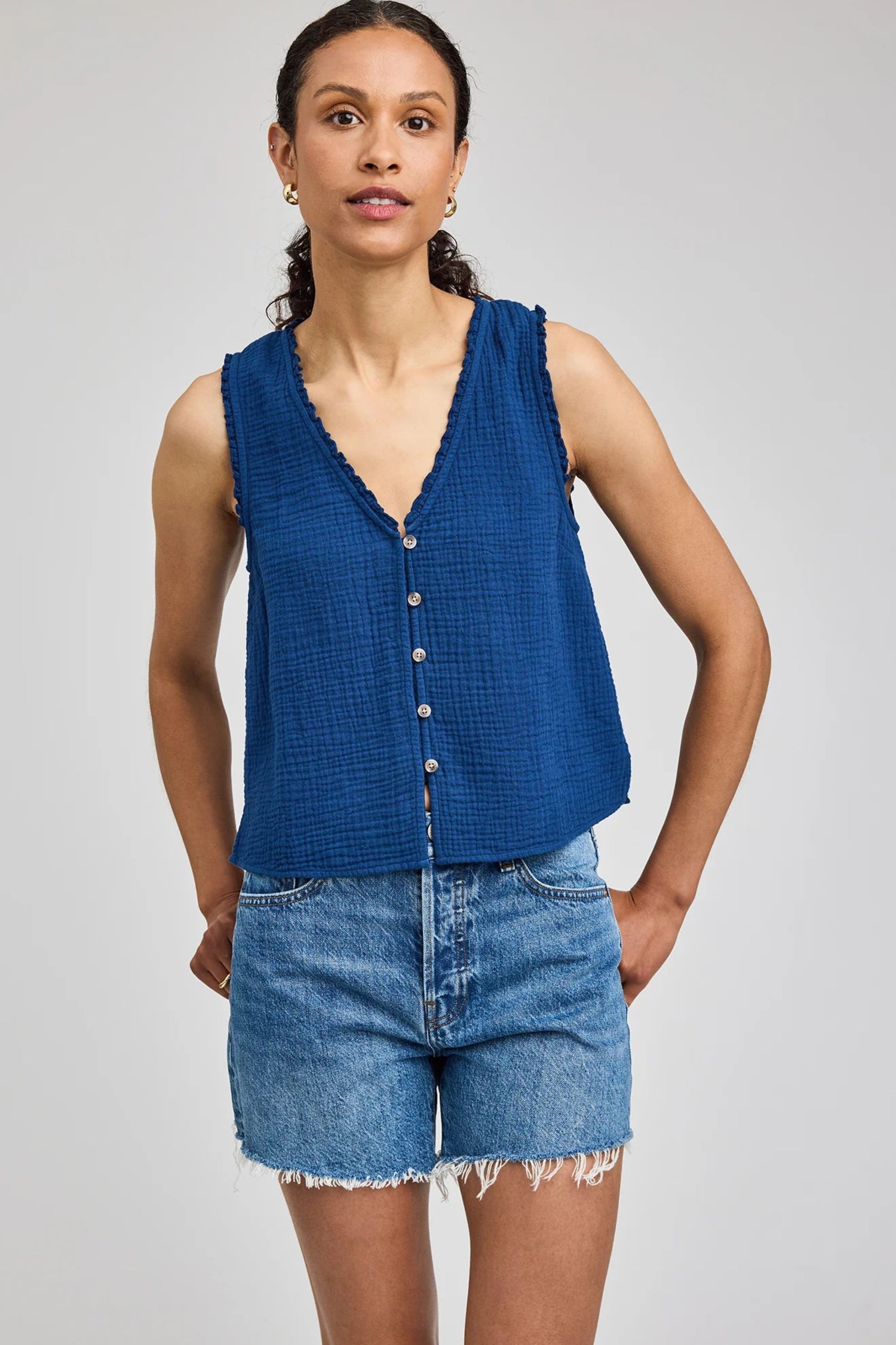 Haut Penelope bleu porté de face avec encolure en V, boutons à l’avant et texture en double gaze de coton.