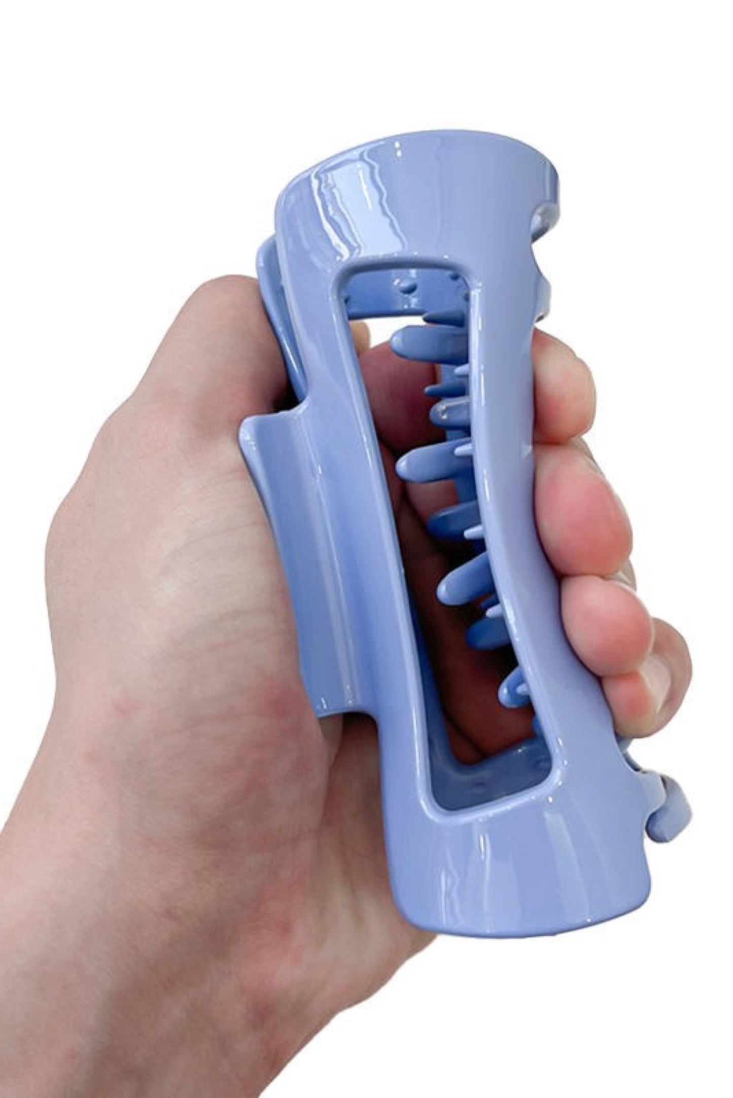 Pince à cheveux rectangle bleu tenue en main – structure souple et incassable