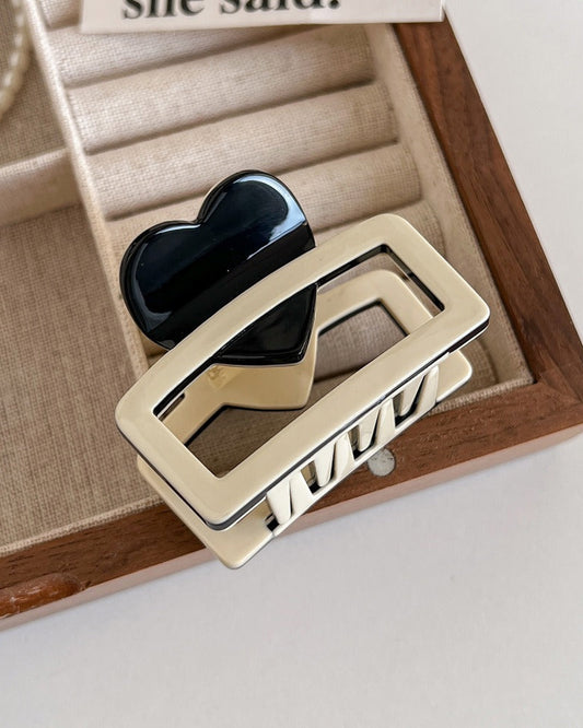 Pince à cheveux rectangulaire bicolore avec cœur noir décoratif, vue de dessus