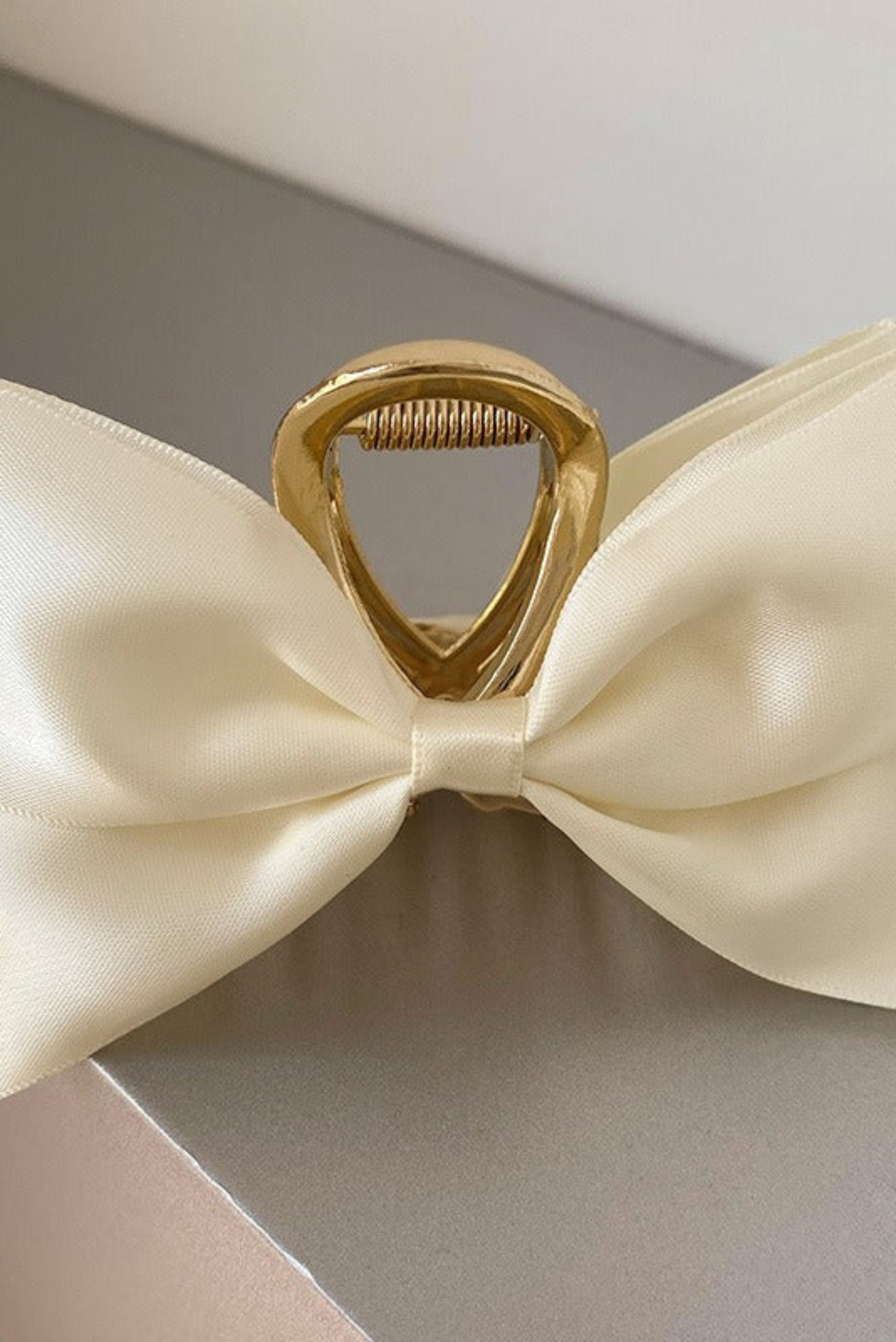 Pince à cheveux blanc cassé en satin avec boucle dorée et grand nœud élégant