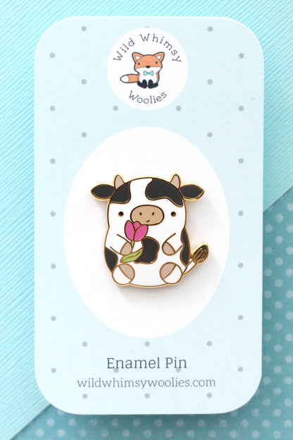 Pin’s en émail vache tenant une tulipe présenté sur carte de support