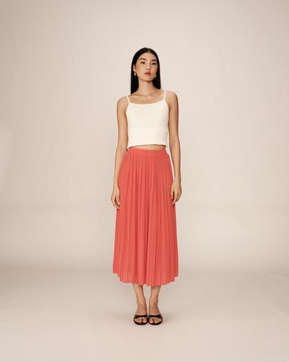 Jupe plissée de la marque Grace & Mila en coloris corail. Cette jupe midi fluide est dotée d'une taille élastique qui s'adapte confortablement à la silhouette. Son tissu léger et aérien crée un mouvement élégant, parfait pour une allure féminine et raffinée. Sa longueur mi-mollet en fait une pièce polyvalente, idéale pour un look casual avec un t-shirt ou plus sophistiqué avec un top ajusté. Un essentiel du dressing pour apporter une touche colorée et chic à votre tenue.