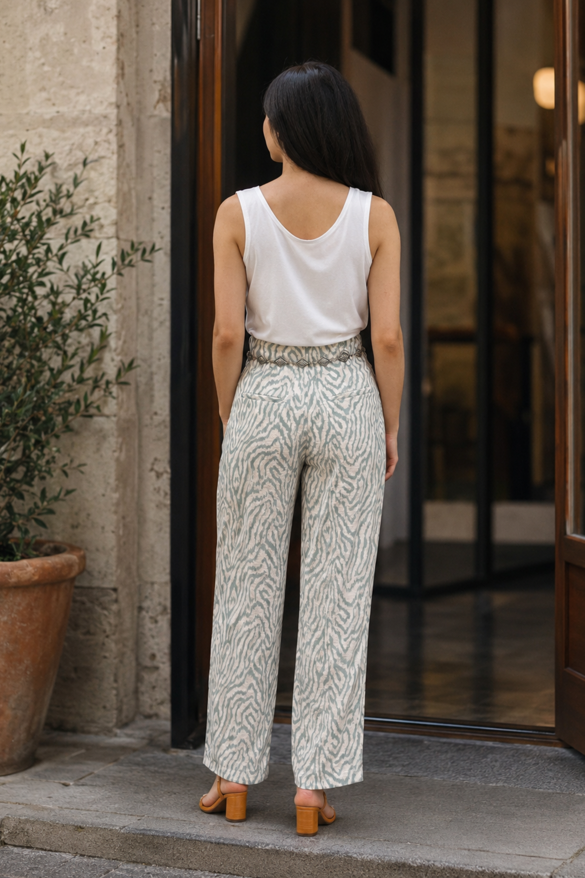 Vue de dos du pantalon Poco blanc à motif animal, avec taille haute, jambe ample et tombé fluide.