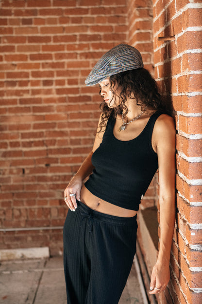 Débardeur Pointelle noir porté – look décontracté contre un mur en brique