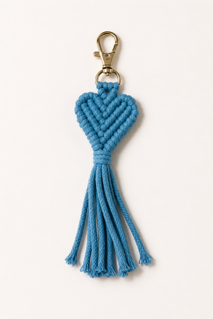 Porte-clé cœur en macramé bleu avec frange et attache dorée, idéal pour décorer un sac ou des clés.