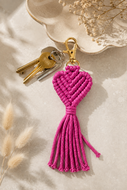 Porte-clé cœur en macramé rose framboise avec attache dorée, style bohème et artisanal.