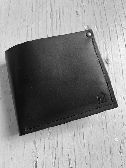 Portefeuilles rectangulaire qui s'ouvre en deux avec à l'intérieure des fentes pour ranger les cartes. Il y a une grande poche horizontale pour ranger les billets. Le portefeuilles est en cuir marron foncé. L'arrière-plan est une planche en bois. 