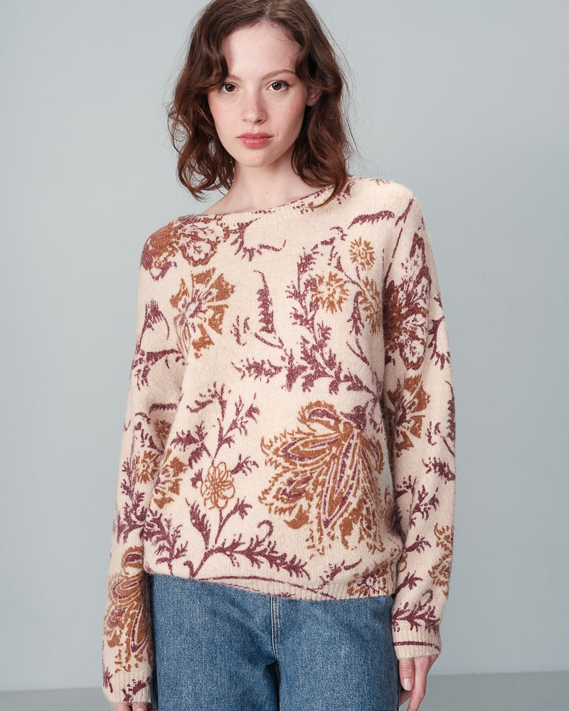 Pull en laine beige fleuri à encolure ronde en laine. Porté avec un jeans par une femme vu de devant.