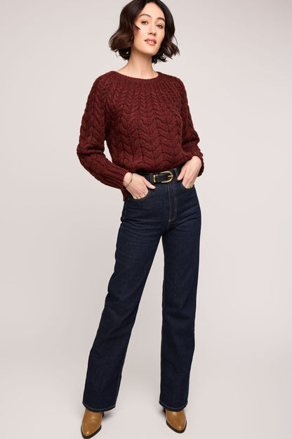 Femme portant le pull Patricia acajou torsadé, look complet avec jean et bottines.