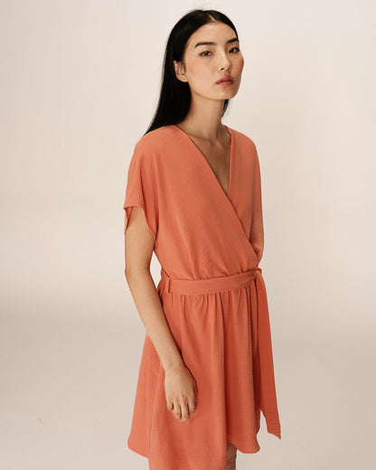 Robe courte papaye portée de profil, taille ceinturée