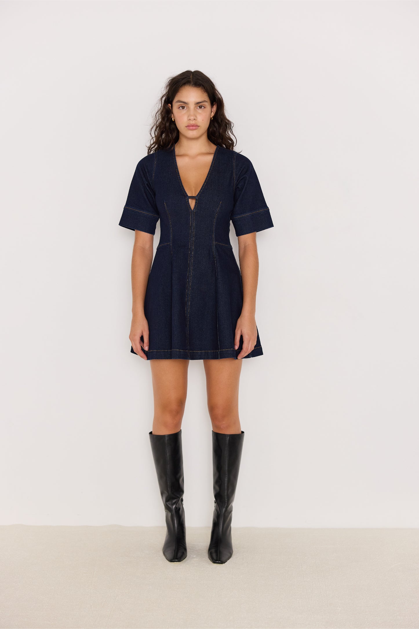 Vue de face de la robe en denim bleu foncé avec col V et coupe évasée