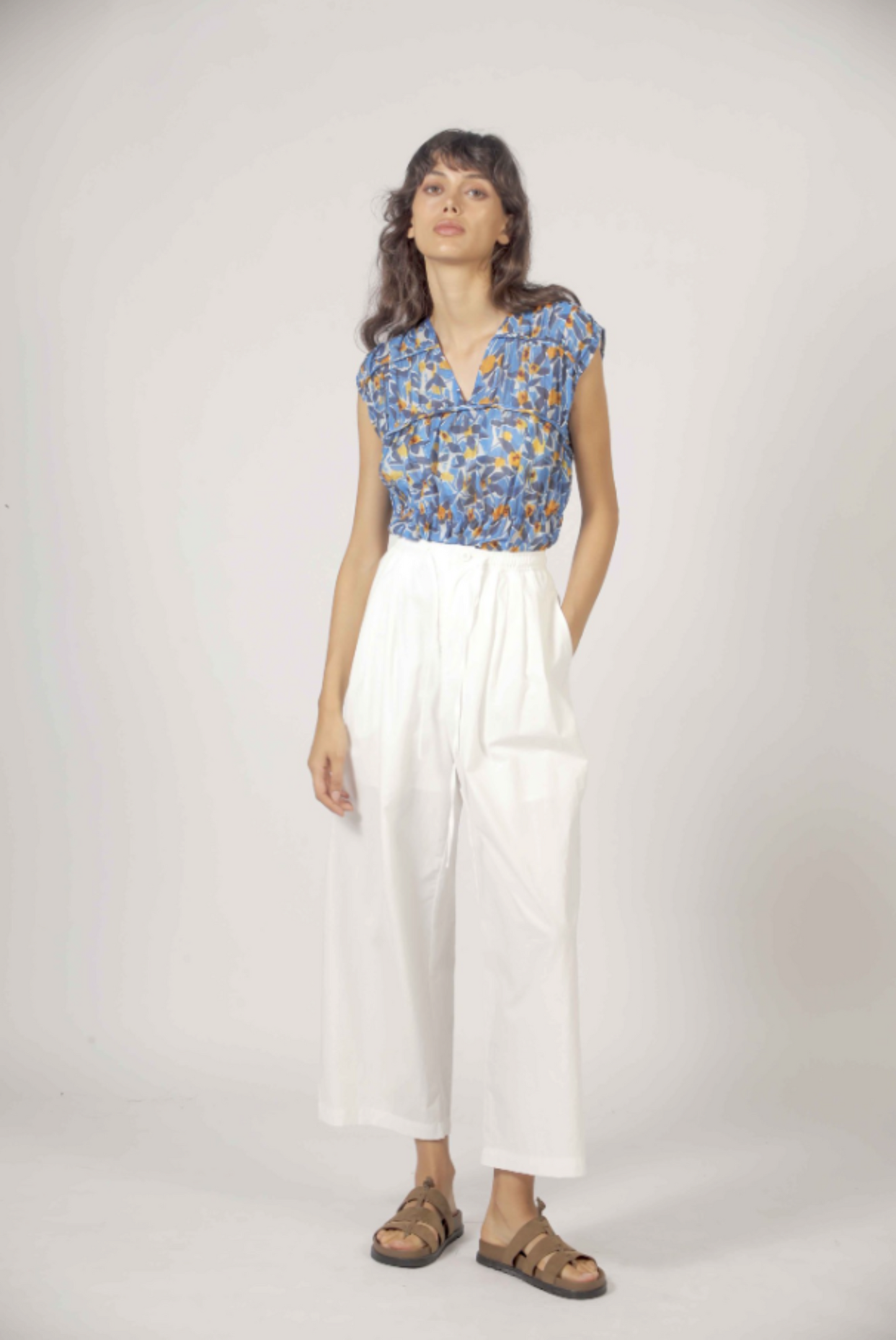 Look complet avec blouse fleurie bleue et pantalon fluide blanc