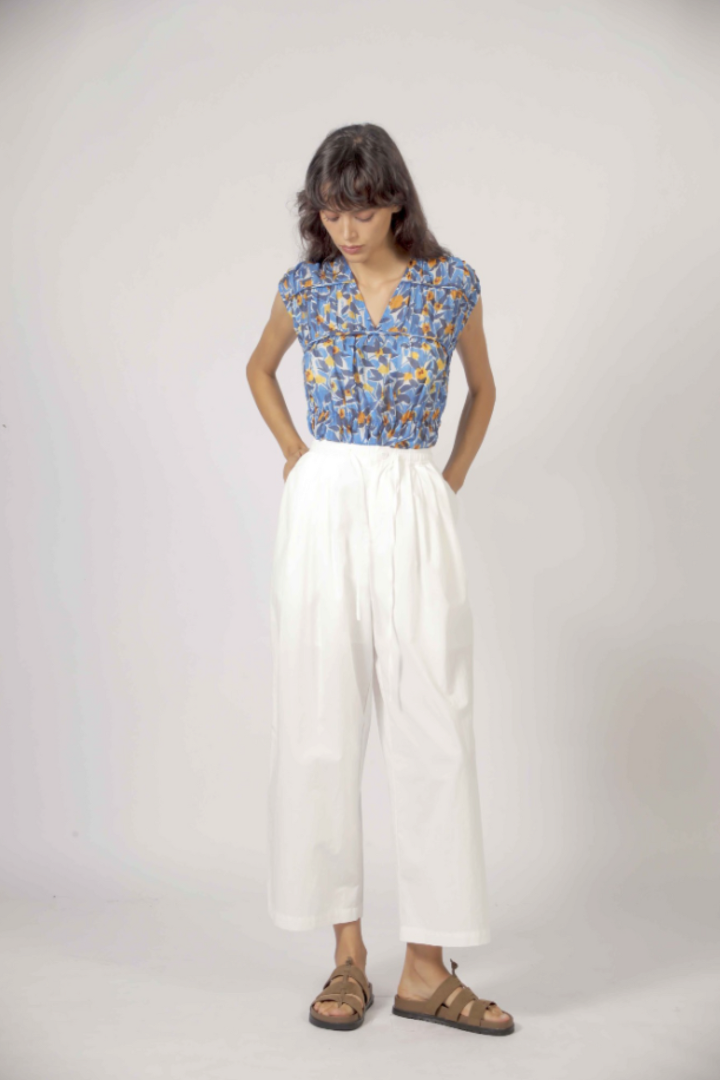 Blouse fleurie bleue portée avec pantalon blanc style chic et léger