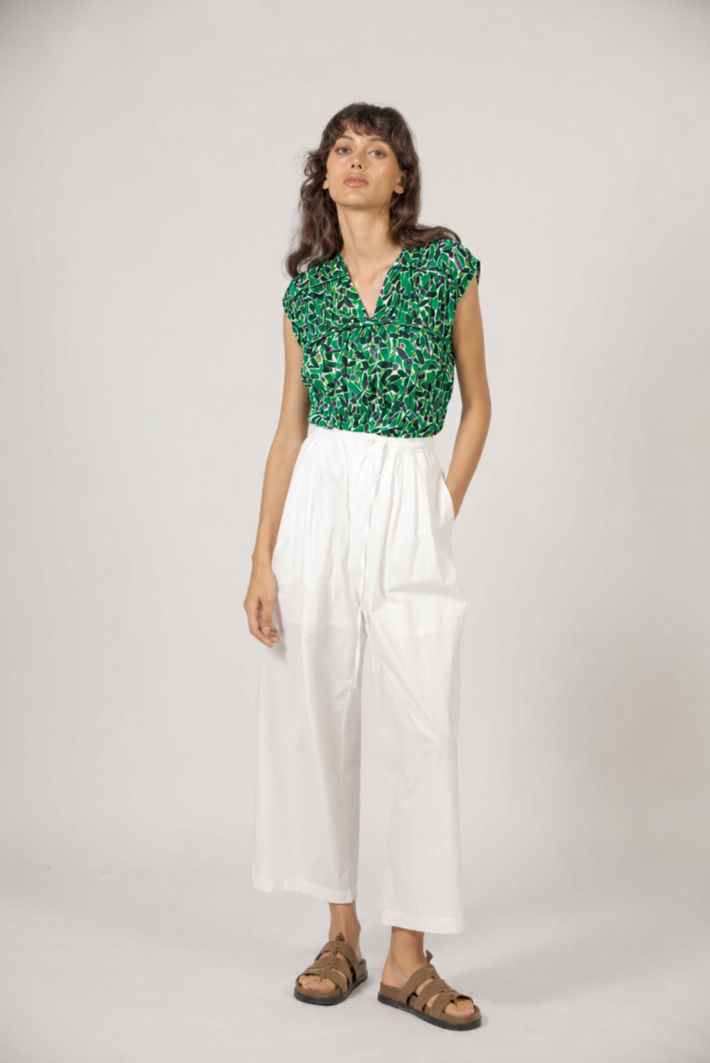 Look complet avec blouse fleurie verte et pantalon fluide blanc
