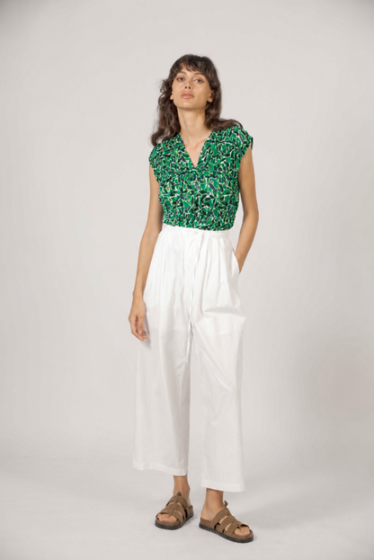 Look complet avec blouse fleurie verte et pantalon fluide blanc