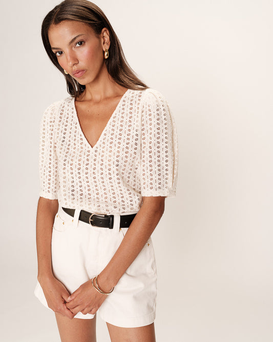 Blouse beige en broderie anglaise avec encolure en V et manches bouffantes