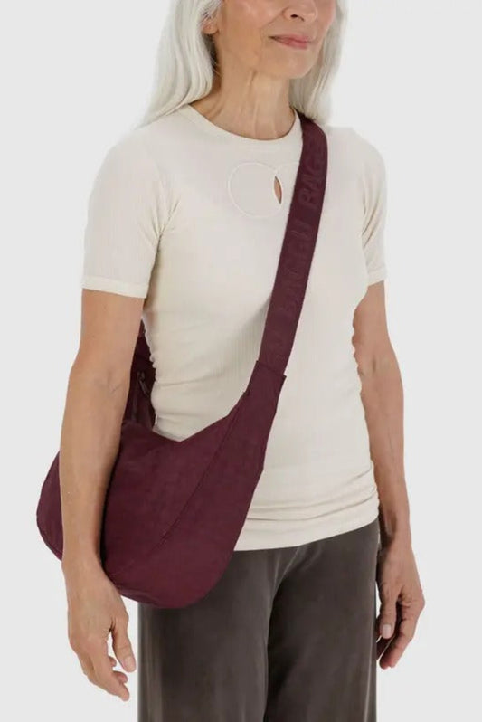 Sac croissant moyen acajou porté à l’épaule, bandoulière ajustable