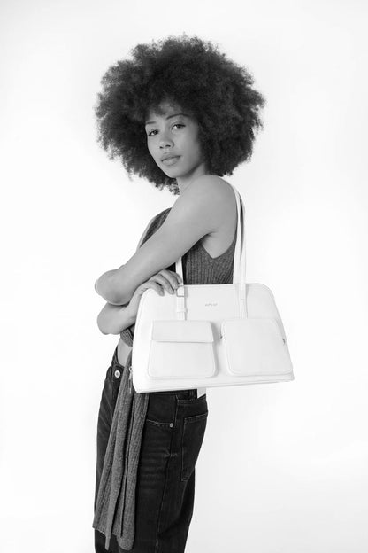 Vue du sac porté à l’épaule, compartiment zippé et poches avant