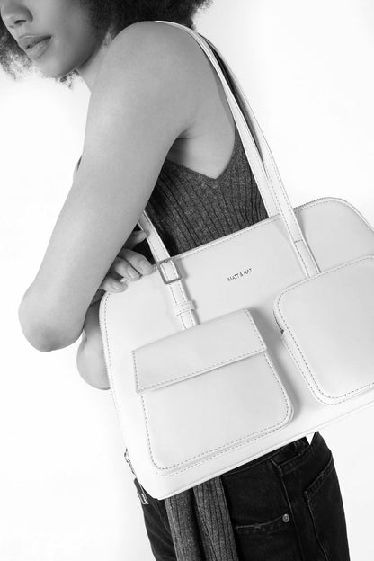 Vue du sac porté à l’épaule, compartiment zippé et poches avant