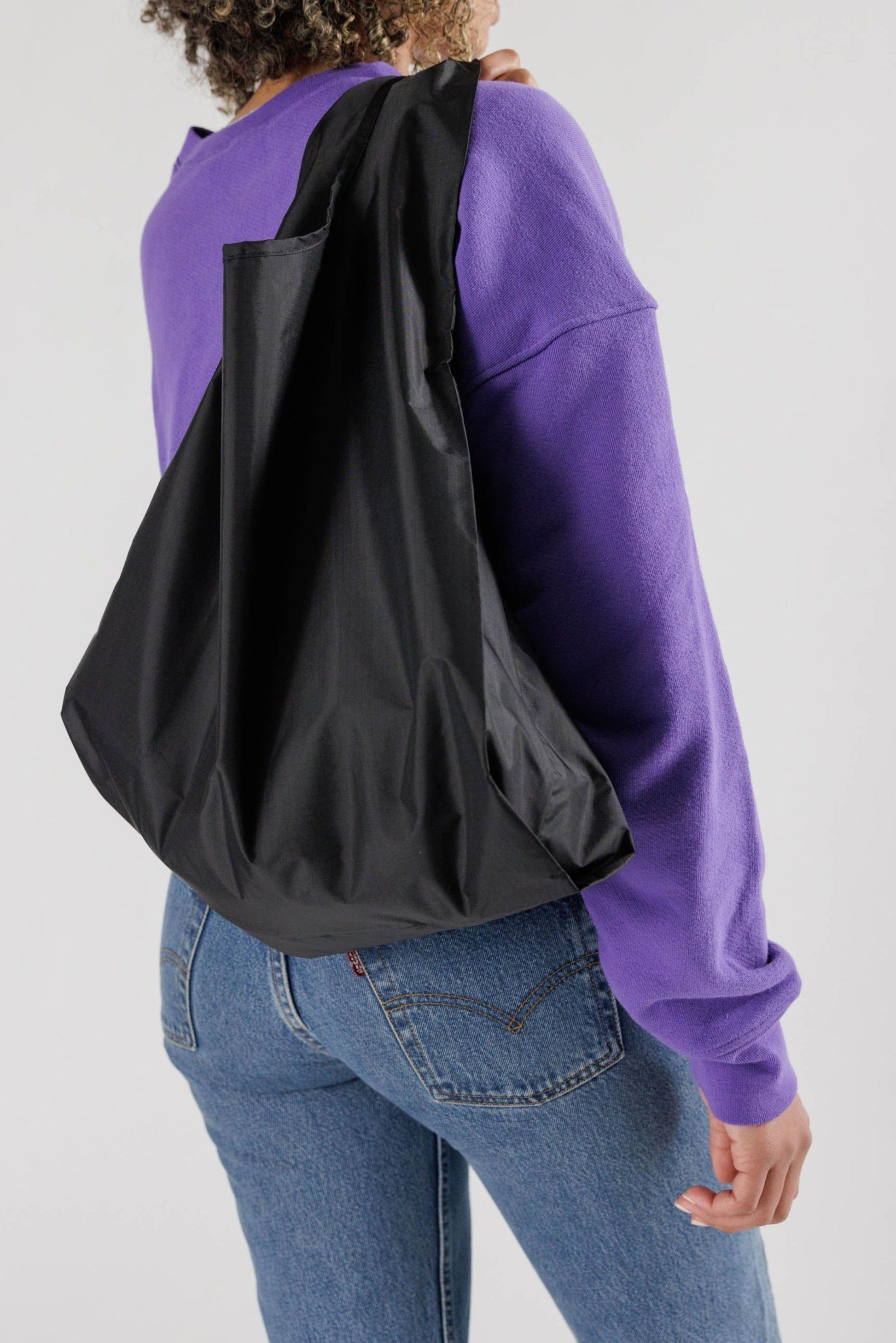 modèle portant le sac réutilisable noir – grand format en nylon recyclé