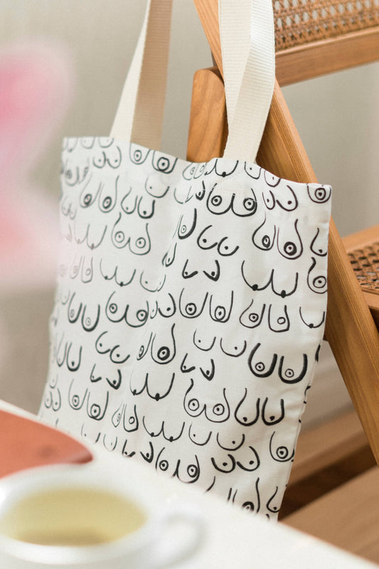 Sac fourre-tout Seins posé sur une chaise en bois – style minimaliste et imprimé artistique.