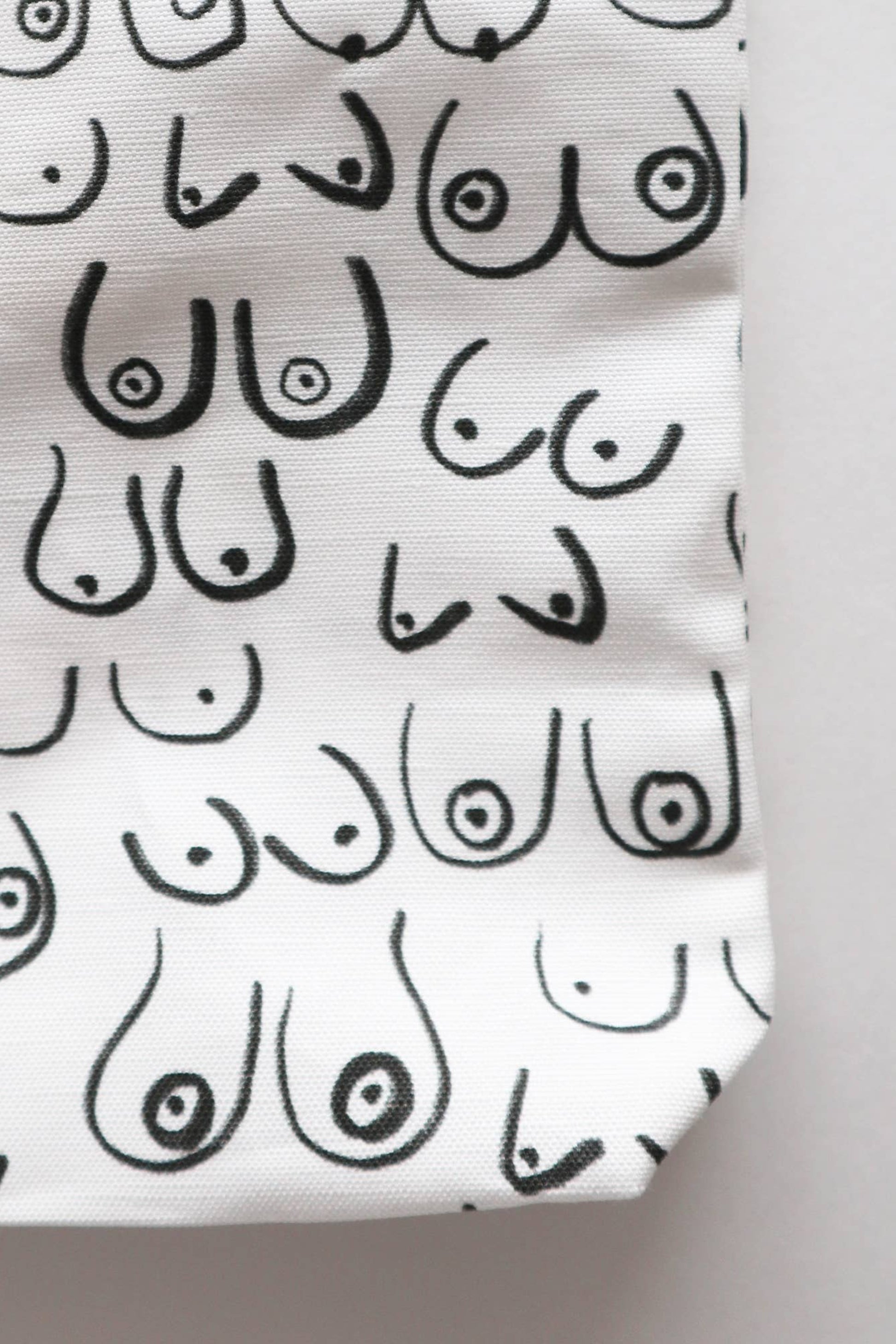 Gros plan sur l’imprimé artistique du sac fourre-tout Seins en toile – motif noir minimaliste.