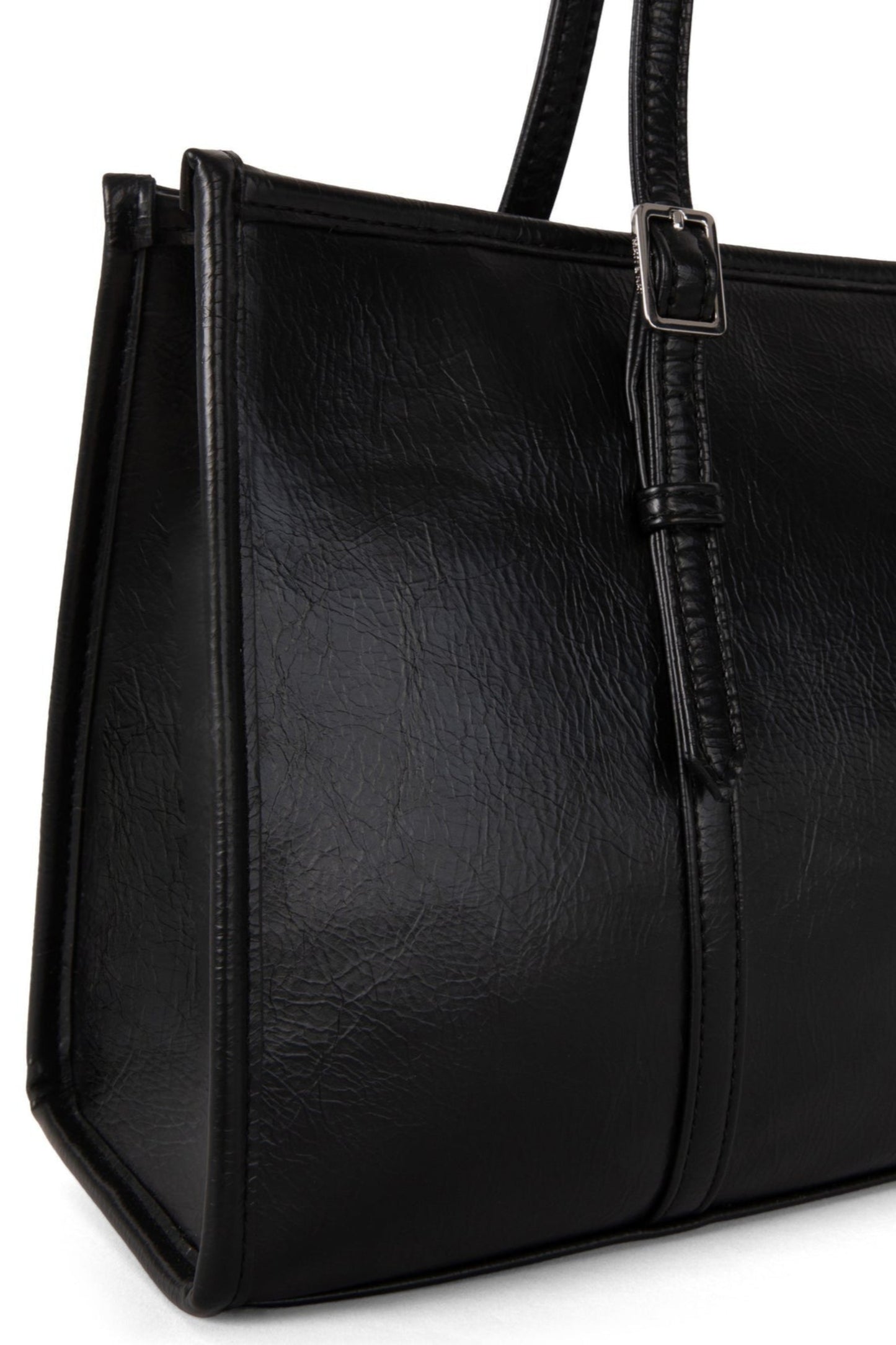 Gros plan sur le sac Zephyr noir, détails des poignées réglables et texture