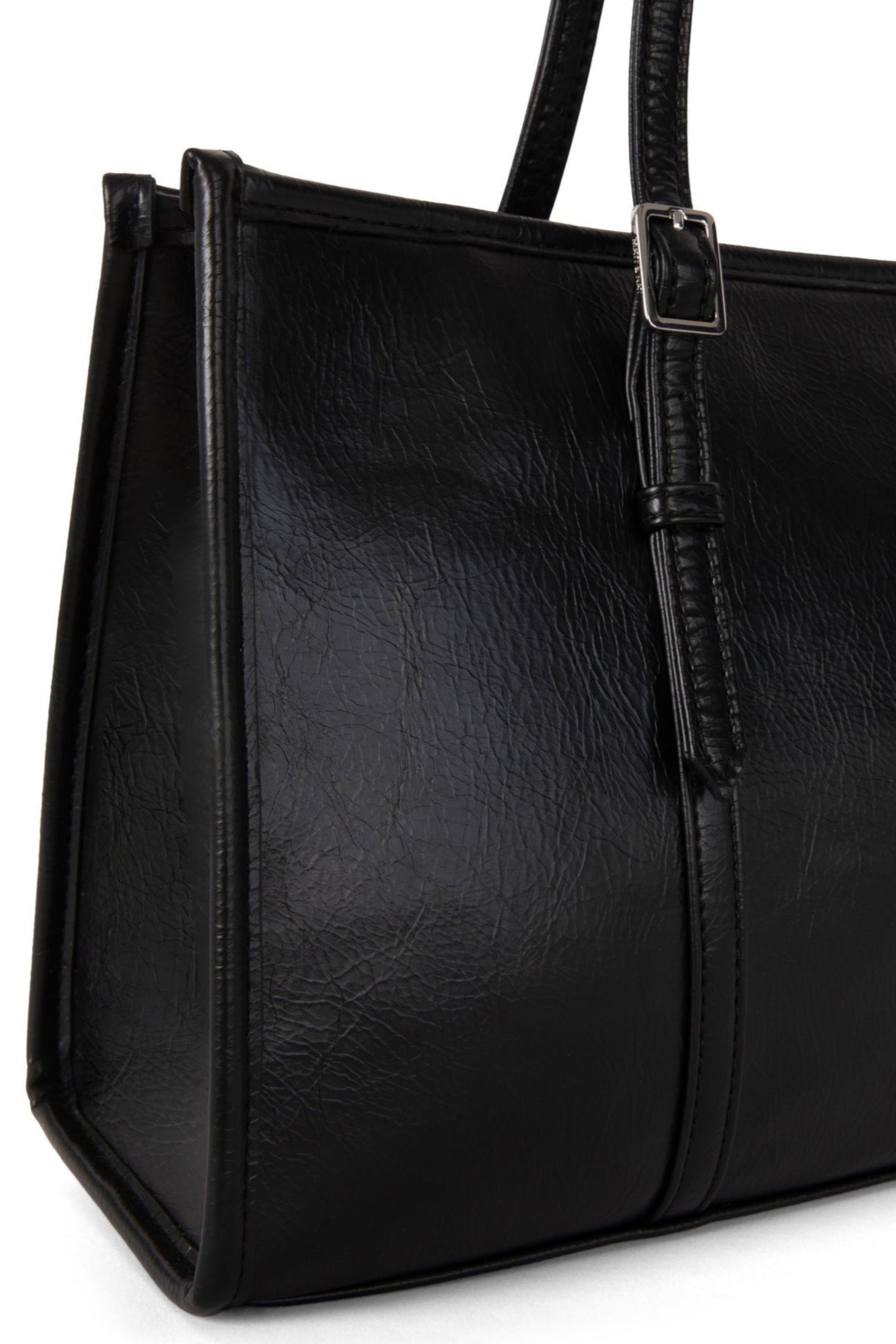 Gros plan sur le sac Zephyr noir, détails des poignées réglables et texture