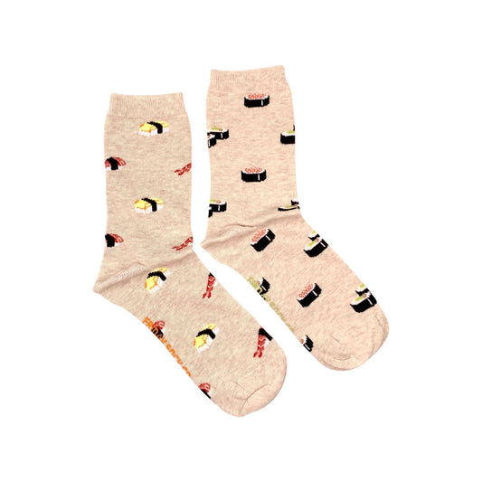 Paire de chaussettes dépareillées sur fond blanc. Les deux chaussettes sont beige. L’une a des sushis de type futomaki et l’autre de type nigiri.