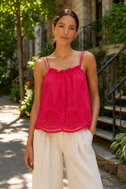 Femme portant le haut Suzanne fuchsia en plan rapproché, avec encolure froncée, broderie anglaise et finition festonnée.