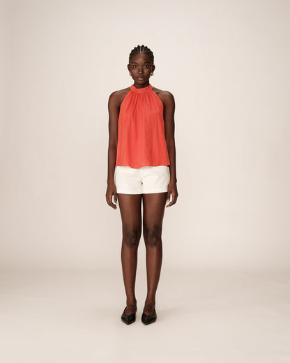 Vue complète du top brodé rouge porté avec short blanc