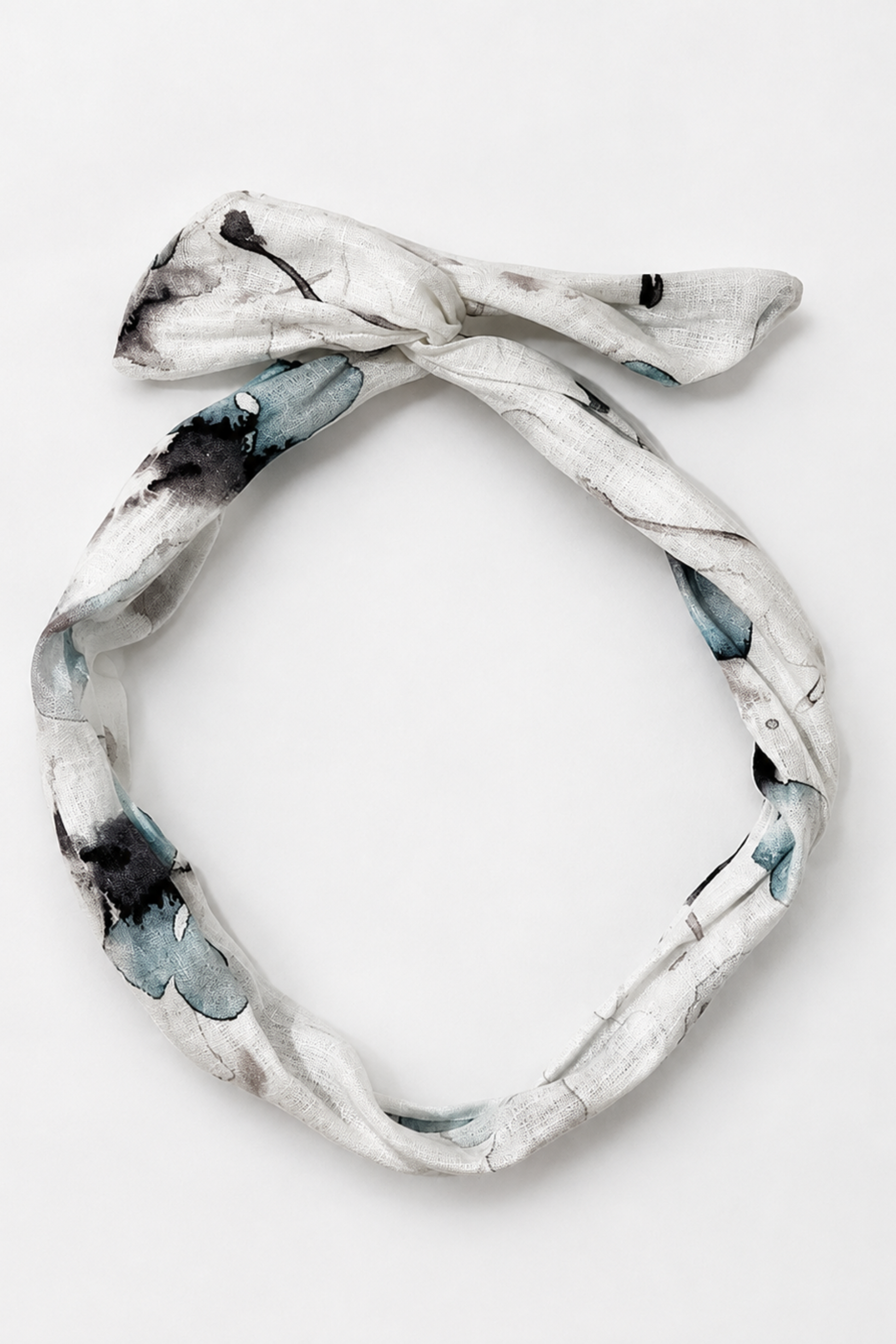 Bandeau en lin fleuri bleu posé à plat, accessoire à torsader avec tige en métal fait à Montréal.