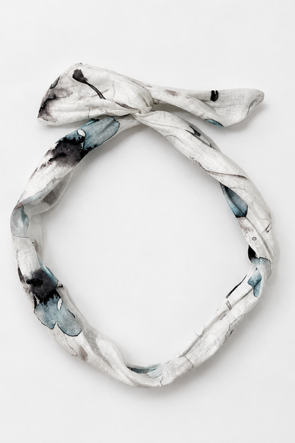 Bandeau en lin fleuri bleu posé à plat, accessoire à torsader avec tige en métal fait à Montréal.