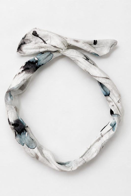 Bandeau en lin fleuri bleu posé à plat, accessoire à torsader avec tige en métal fait à Montréal.