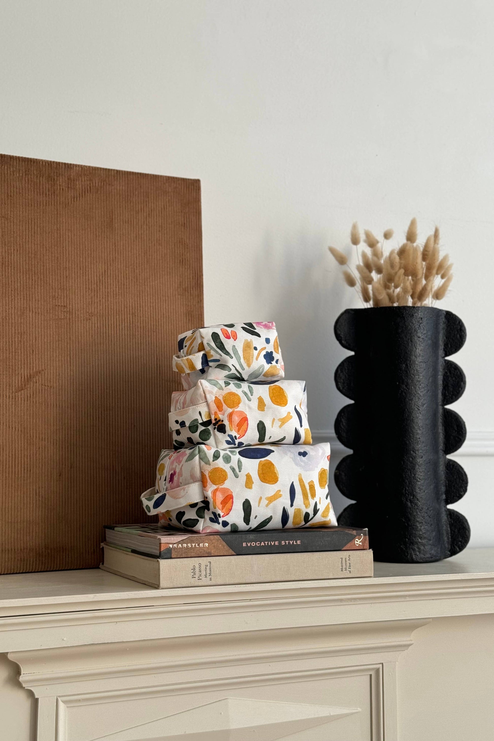 Trousse fleurie multicolore en coton bio empilée avec autres formats, motif floral multicolore
