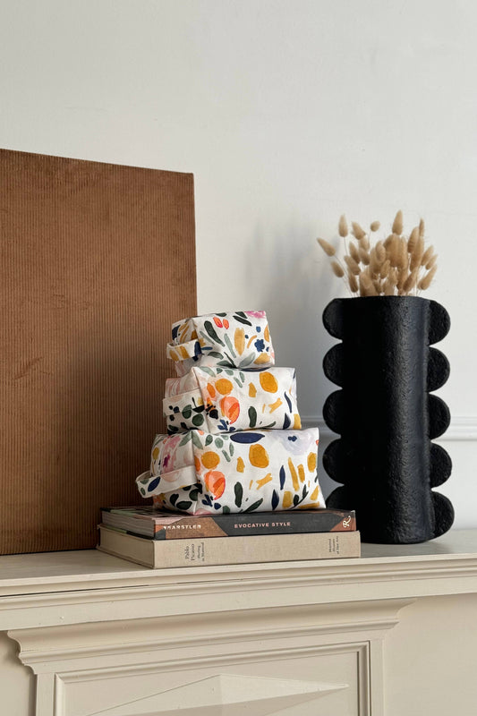 Trousse fleurie multicolore en coton bio empilée avec autres formats, motif floral multicolore